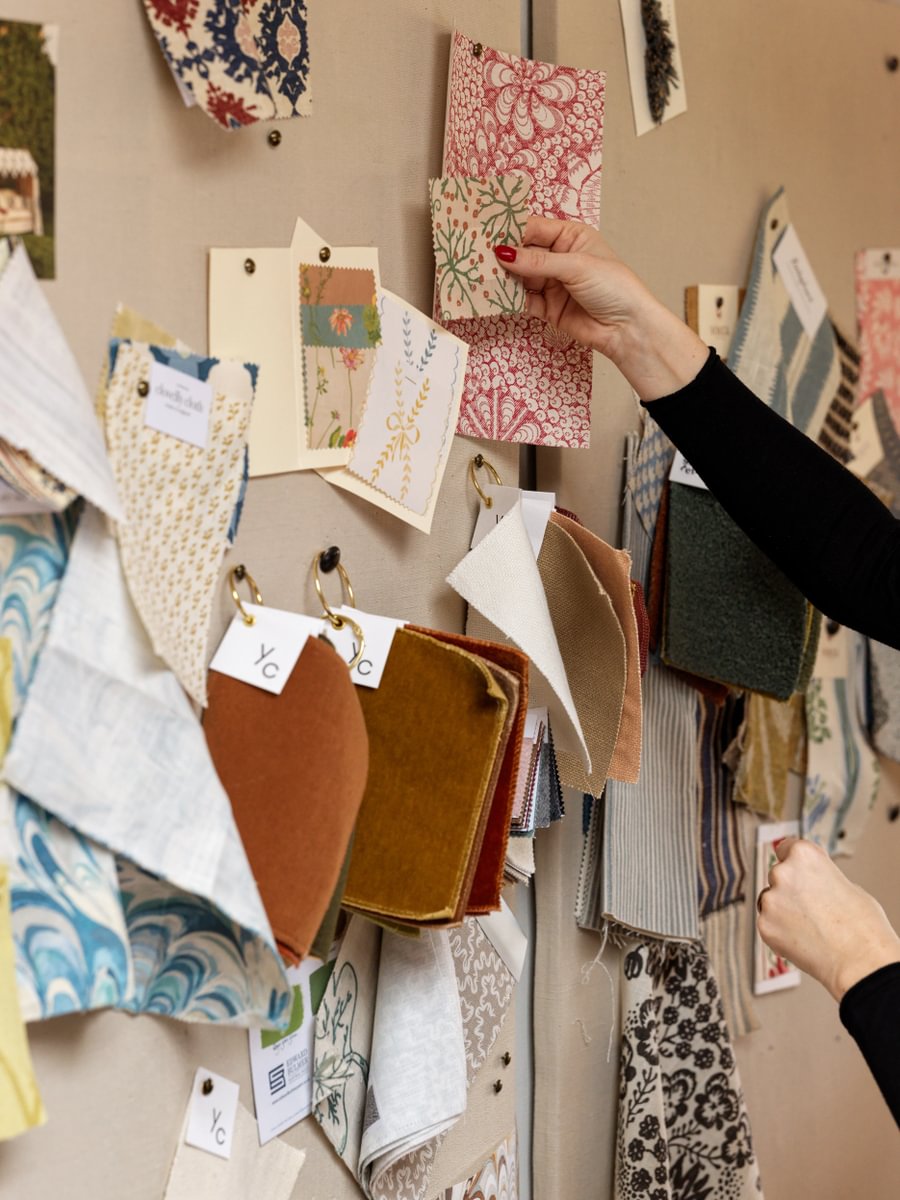 Hands Scheming With Fabric And Wallpaper Samples