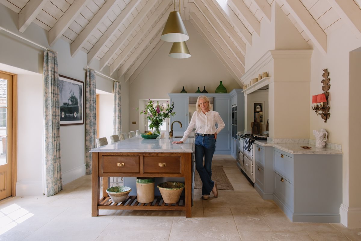 Emma Sims Hilditch Leaning Against Kitchen Island